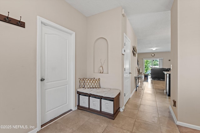 4008 Cormorant Ln, Middleburg, FL 32068 - hall featuring a textured ceiling, light tile patterned flooring, and baseboards