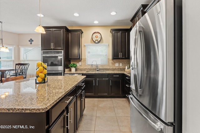4008 Cormorant Ln, Middleburg, FL 32068 - kitchen with appliances with stainless steel finishes, a sink, tasteful backsplash, a center island, and decorative light fixtures