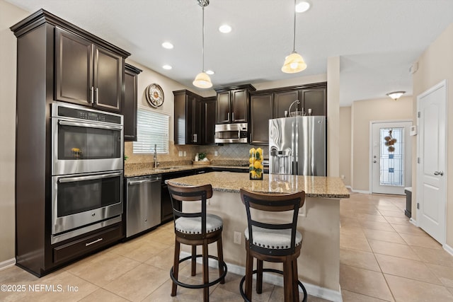 4008 Cormorant Ln, Middleburg, FL 32068 - kitchen with stainless steel appliances, light tile patterned flooring, tasteful backsplash, light stone countertops, and recessed lighting