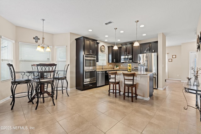 4008 Cormorant Ln, Middleburg, FL 32068 - kitchen featuring stainless steel appliances, decorative backsplash, a center island, a kitchen breakfast bar, and baseboards