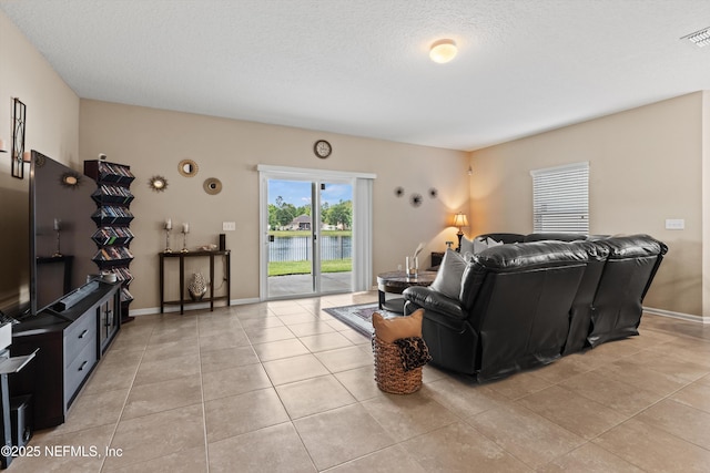 4008 Cormorant Ln, Middleburg, FL 32068 - living room featuring light tile patterned floors, a textured ceiling, baseboards, and a water view