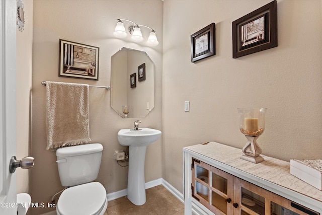 4008 Cormorant Ln, Middleburg, FL 32068 - bathroom featuring toilet, tile patterned floors, baseboards, and a sink