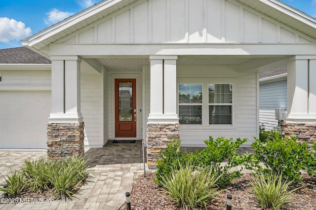 1459 Stillwater Blvd, Saint Johns, FL 32259 - doorway to property featuring board and batten siding, stone siding, an attached garage, and a shingled roof