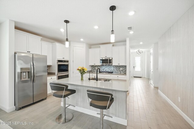 1459 Stillwater Blvd, Saint Johns, FL 32259 - kitchen featuring appliances with stainless steel finishes, light wood-style floors, tasteful backsplash, baseboards, and a sink