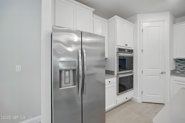 1459 Stillwater Blvd, Saint Johns, FL 32259 - kitchen featuring appliances with stainless steel finishes, white cabinetry, light countertops, light wood-style floors, and tasteful backsplash