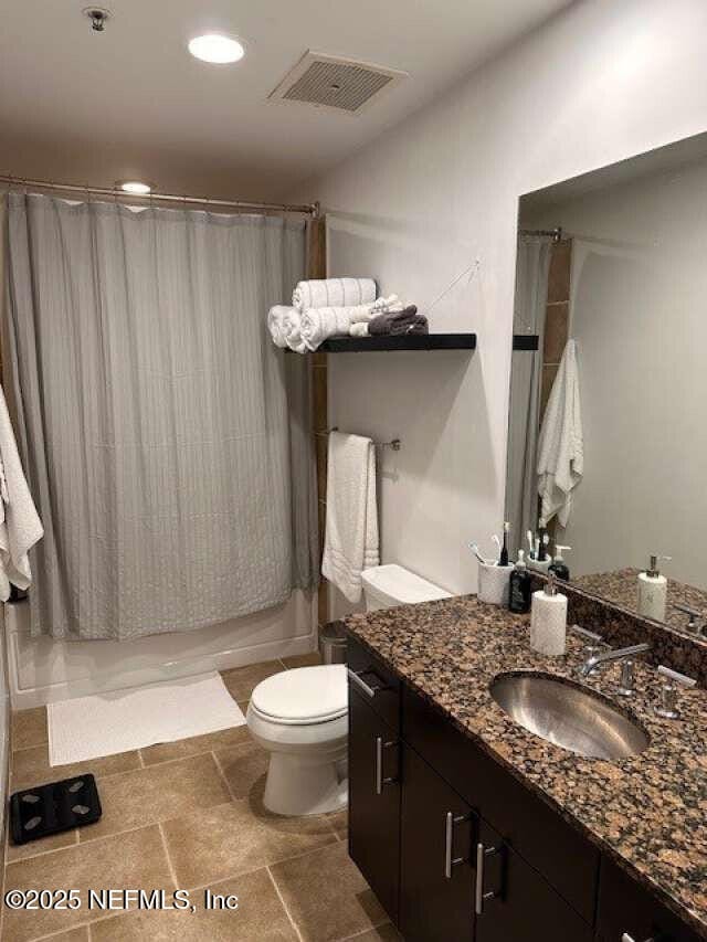 bathroom with toilet, vanity, and shower / bath combination with curtain