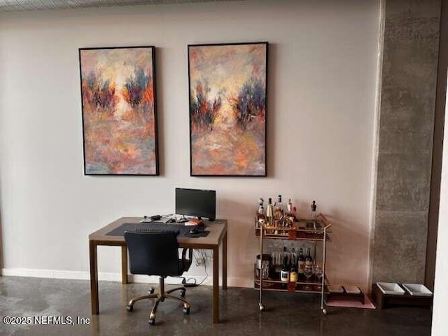 office area with baseboards and concrete floors