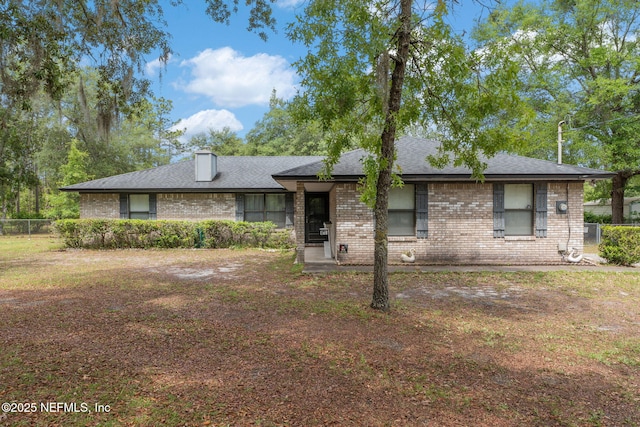 2658 Apache Ct, Middleburg, FL 32068 - view of front of property featuring brick siding, fence, a shingled roof, and a chimney