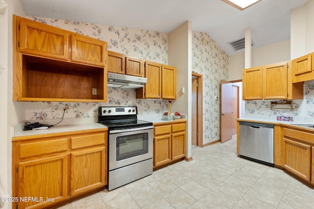 2658 Apache Ct, Middleburg, FL 32068 - kitchen with appliances with stainless steel finishes, under cabinet range hood, wallpapered walls, light countertops, and a textured ceiling
