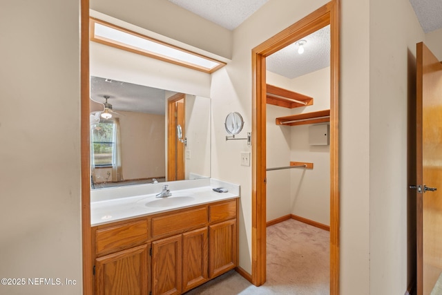 2658 Apache Ct, Middleburg, FL 32068 - bathroom with a textured ceiling, vanity, ceiling fan, and baseboards