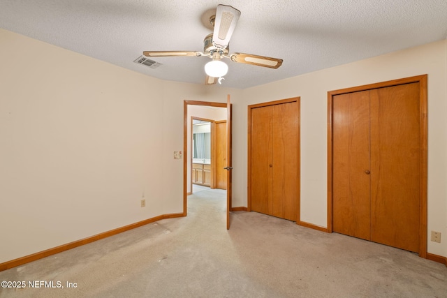 2658 Apache Ct, Middleburg, FL 32068 - unfurnished bedroom with multiple closets, light colored carpet, baseboards, a ceiling fan, and a textured ceiling