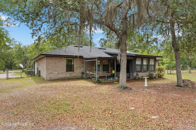 2658 Apache Ct, Middleburg, FL 32068 - rear view of house with brick siding, fence, a shingled roof, a gate, and a sunroom