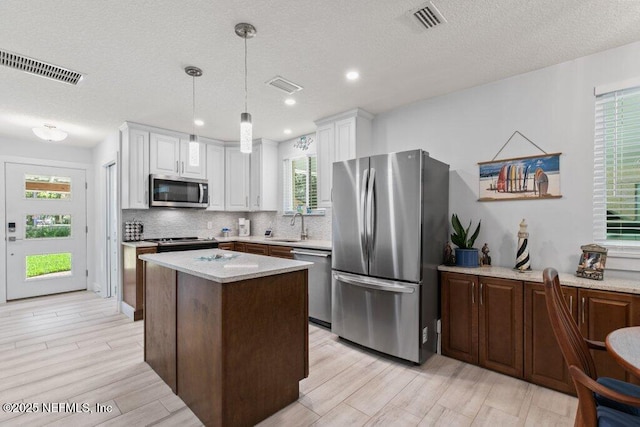 8211 Colee Cove Branch Rd Unit G, Saint Augustine, FL 32092 - kitchen featuring appliances with stainless steel finishes, a sink, tasteful backsplash, light countertops, and a center island