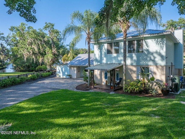 8211 Colee Cove Branch Rd Unit G, Saint Augustine, FL 32092 - view of front facade featuring gravel driveway, a front lawn, metal roof, and a chimney