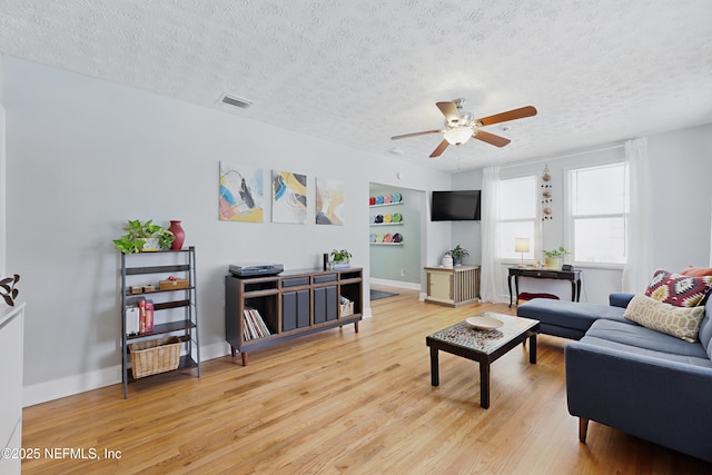 5327 Attleboro St, Jacksonville, FL 32205 - living room with a ceiling fan, light wood finished floors, a textured ceiling, built in shelves, and baseboards