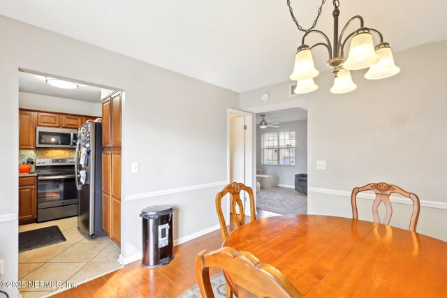 1101 Kettering Way, Orange Park, FL 32073 - dining space featuring a chandelier, a ceiling fan, and baseboards