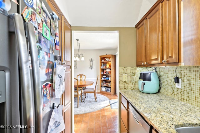 1101 Kettering Way, Orange Park, FL 32073 - kitchen with stainless steel appliances, backsplash, light wood finished floors, and brown cabinets