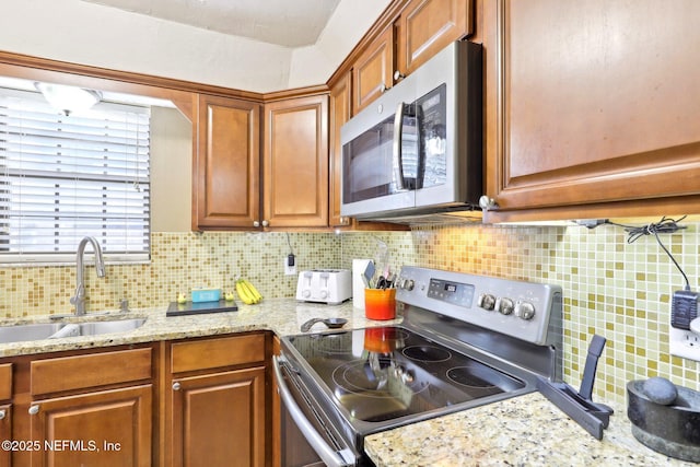 1101 Kettering Way, Orange Park, FL 32073 - kitchen featuring appliances with stainless steel finishes, a sink, backsplash, and brown cabinetry