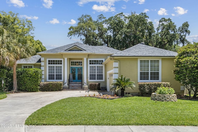 2738 Sea Grove Ln, Fernandina Beach, FL 32034 - view of front of house with stucco siding, a front yard, french doors, roof with shingles, and concrete driveway