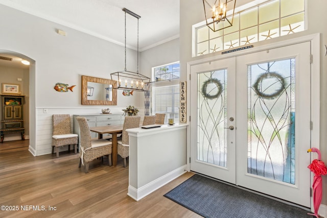 2738 Sea Grove Ln, Fernandina Beach, FL 32034 - entryway featuring arched walkways, a chandelier, crown molding, wood finished floors, and baseboards