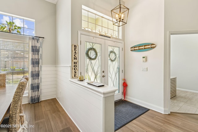 2738 Sea Grove Ln, Fernandina Beach, FL 32034 - entryway featuring a chandelier, wood finished floors, a high ceiling, and wainscoting