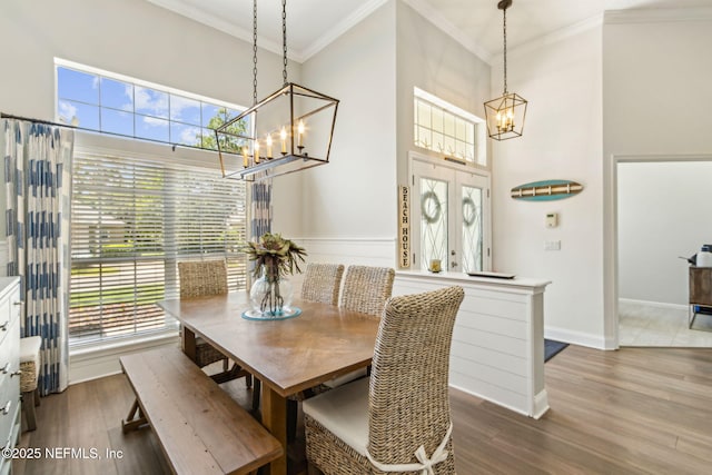 2738 Sea Grove Ln, Fernandina Beach, FL 32034 - dining room with a chandelier, crown molding, a towering ceiling, wood finished floors, and baseboards