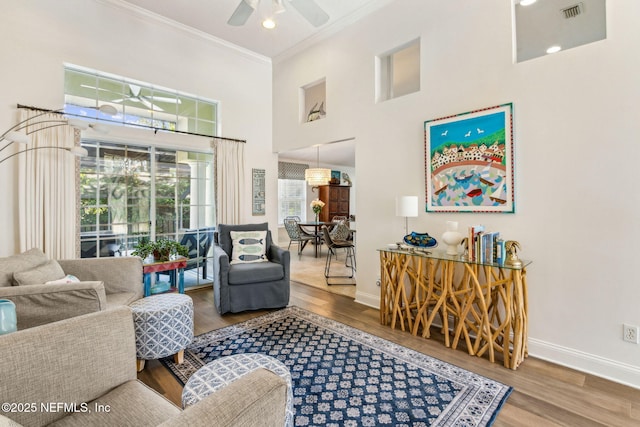 2738 Sea Grove Ln, Fernandina Beach, FL 32034 - living area with crown molding, wood finished floors, a ceiling fan, baseboards, and a high ceiling