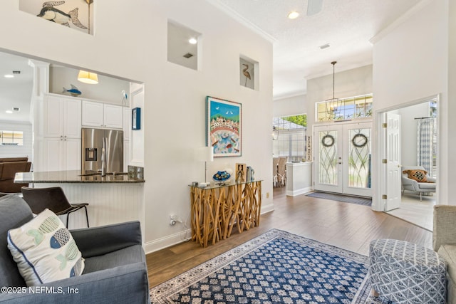2738 Sea Grove Ln, Fernandina Beach, FL 32034 - living area featuring ornamental molding, a high ceiling, wood finished floors, baseboards, and french doors