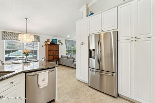 2738 Sea Grove Ln, Fernandina Beach, FL 32034 - kitchen featuring appliances with stainless steel finishes, crown molding, a chandelier, stone counters, and white cabinets