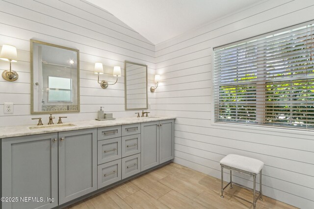 2738 Sea Grove Ln, Fernandina Beach, FL 32034 - bathroom with lofted ceiling, double vanity, wood walls, and wood finished floors