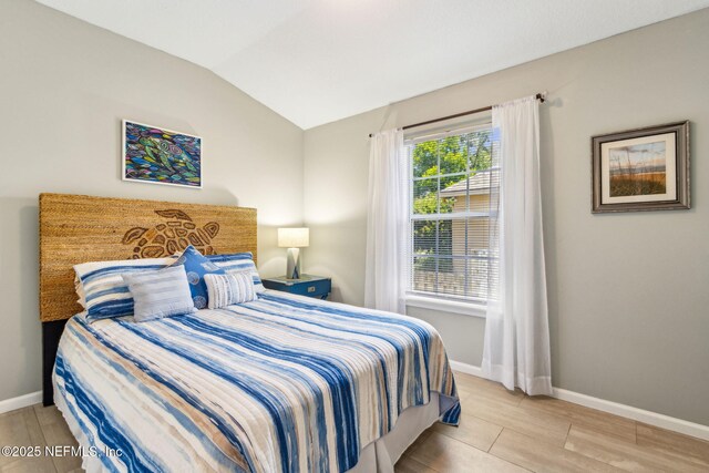 2738 Sea Grove Ln, Fernandina Beach, FL 32034 - bedroom featuring vaulted ceiling, baseboards, and wood finished floors