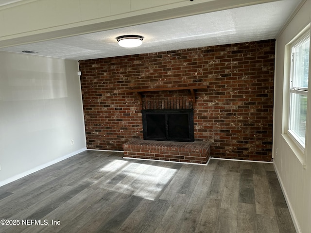 234 Canis St W, Orange Park, FL 32073 - unfurnished living room with wood finished floors, a fireplace, a textured ceiling, baseboards, and brick wall