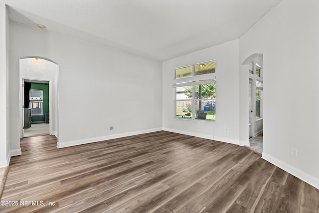 129 Lake Run Blvd, Jacksonville, FL 32218 - empty room featuring arched walkways, healthy amount of natural light, wood finished floors, and baseboards
