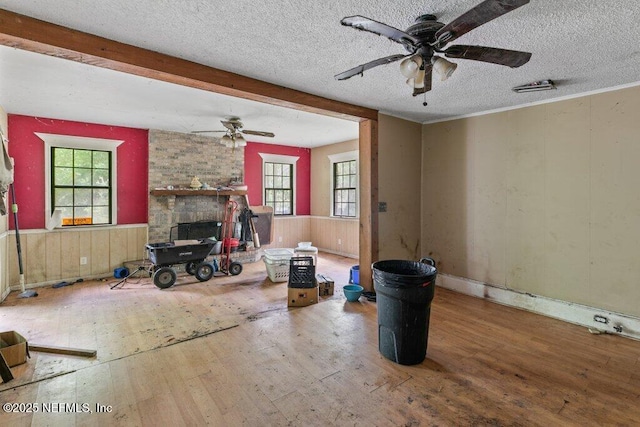 8563 Moncrief-Dinsmore Rd, Jacksonville, FL 32219 - living room featuring a ceiling fan, wood-type flooring, healthy amount of natural light, a textured ceiling, and wood walls