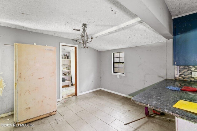 8563 Moncrief-Dinsmore Rd, Jacksonville, FL 32219 - unfurnished dining area featuring a chandelier, a textured ceiling, and baseboards