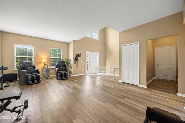 97054 Huntington Ct, Yulee, FL 32097 - living room featuring wood finished floors, baseboards, a textured ceiling, and a towering ceiling