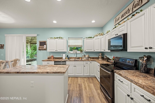 97054 Huntington Ct, Yulee, FL 32097 - kitchen featuring black microwave, double oven range, a sink, white cabinetry, and recessed lighting