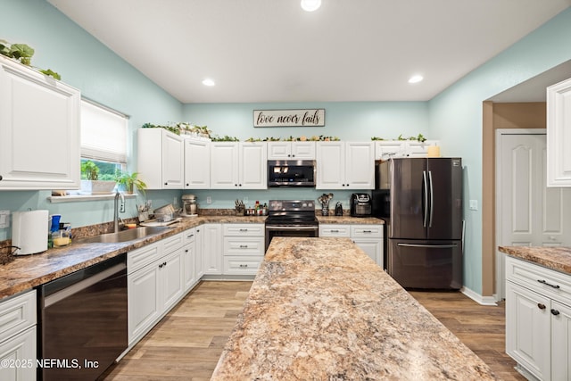 97054 Huntington Ct, Yulee, FL 32097 - kitchen featuring stainless steel appliances, a sink, white cabinetry, light wood-style flooring, and recessed lighting