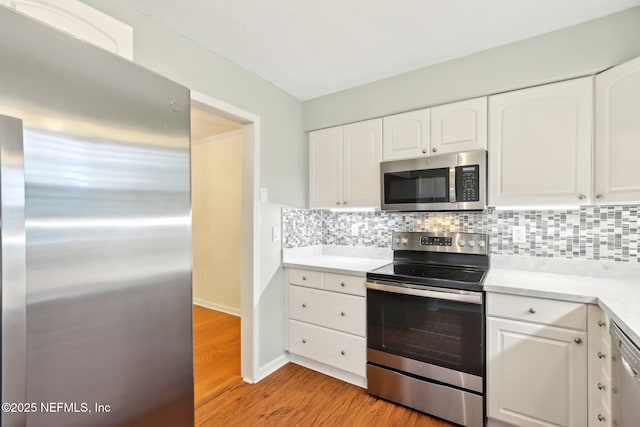 5201 Atlantic Blvd Unit 142, Jacksonville, FL 32207 - kitchen with stainless steel appliances, backsplash, white cabinetry, and light wood-style floors