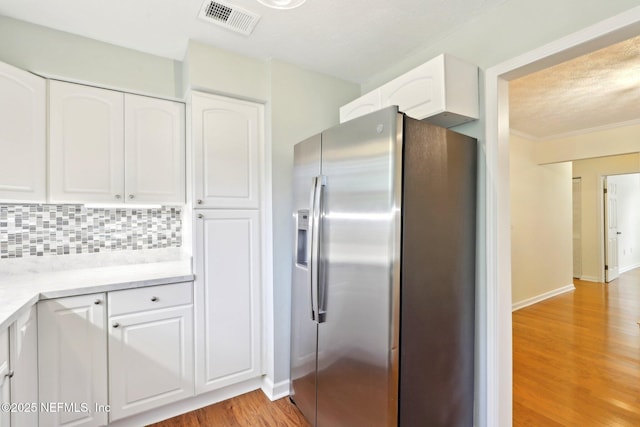 5201 Atlantic Blvd Unit 142, Jacksonville, FL 32207 - kitchen with stainless steel fridge with ice dispenser, light wood-type flooring, white cabinetry, decorative backsplash, and baseboards