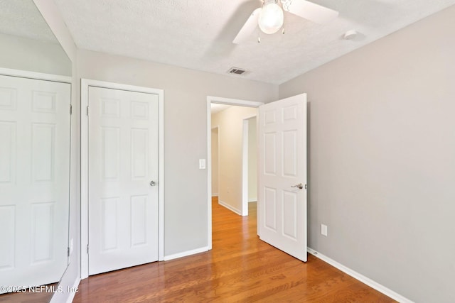 5201 Atlantic Blvd Unit 142, Jacksonville, FL 32207 - unfurnished bedroom featuring wood finished floors, baseboards, a ceiling fan, and a textured ceiling