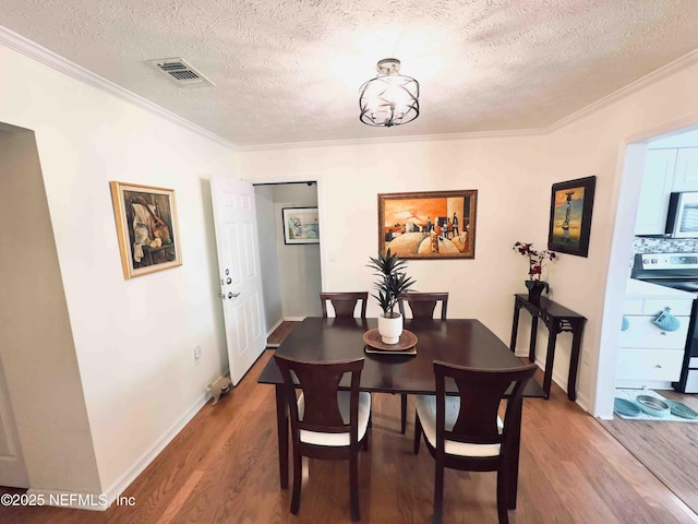 5201 Atlantic Blvd Unit 142, Jacksonville, FL 32207 - dining area featuring crown molding, wood finished floors, a textured ceiling, and baseboards