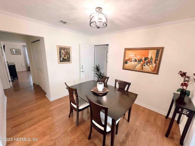 5201 Atlantic Blvd Unit 142, Jacksonville, FL 32207 - dining area featuring a textured ceiling, light wood finished floors, ornamental molding, baseboards, and a chandelier