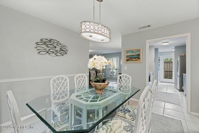 1773 Mariners Walk, Fernandina Beach, FL 32034 - dining room featuring a textured ceiling, light tile patterned flooring, and baseboards