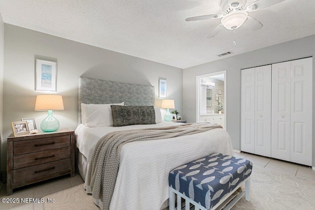 1773 Mariners Walk, Fernandina Beach, FL 32034 - bedroom with light tile patterned flooring, a closet, ensuite bath, a textured ceiling, and ceiling fan