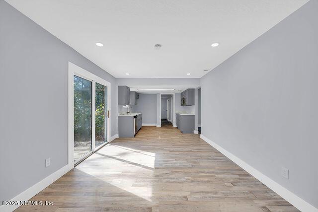 unfurnished living room featuring baseboards, light wood finished floors, and recessed lighting