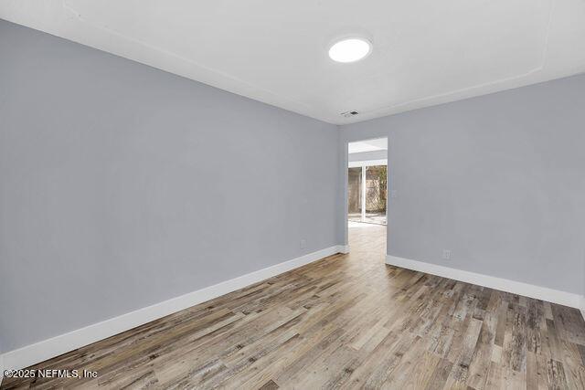 empty room with baseboards and wood finished floors
