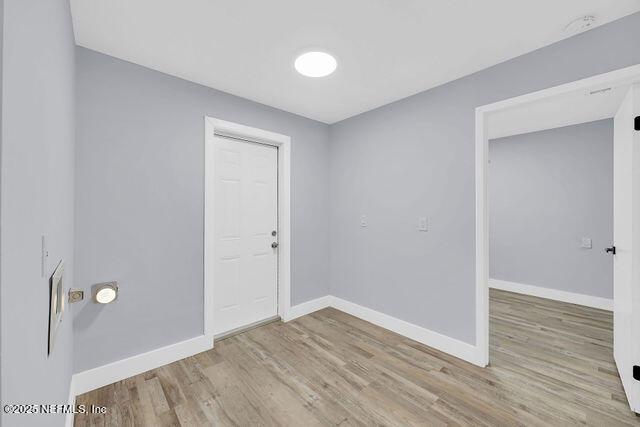 empty room featuring baseboards and wood finished floors