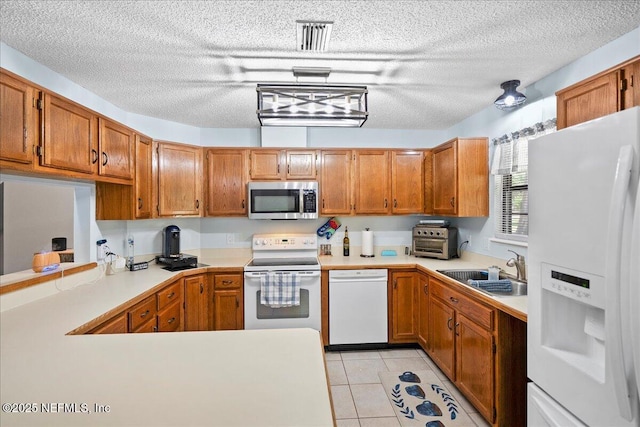 4310 Chokeberry Rd, Middleburg, FL 32068 - kitchen featuring white appliances, a sink, a textured ceiling, brown cabinetry, and light countertops
