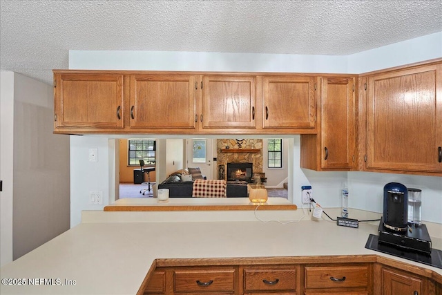 4310 Chokeberry Rd, Middleburg, FL 32068 - kitchen with light countertops, brown cabinetry, a fireplace, and a textured ceiling